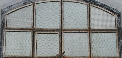 Een stalen raam met glas met verschillende draadpatronen.