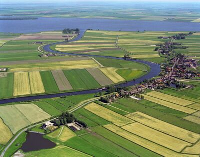 Luchtfoto van de Eem bij Eemdijk. Hij meandert door de groene weilanden en akkers.