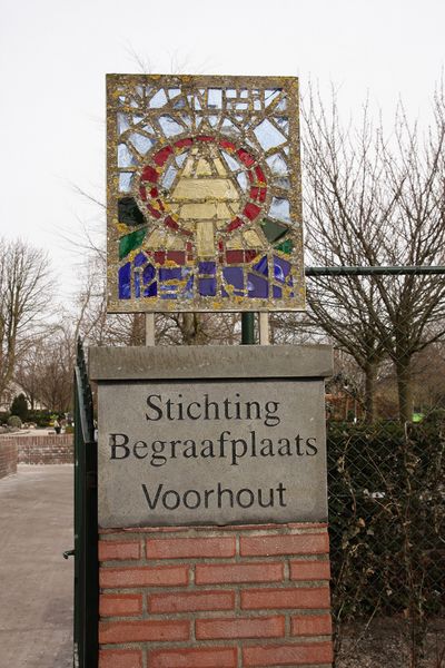 Toegang tot kerkhof in Voorhout met een steen met inscriptie 'Stichting Begraafplaats Voorhout'.