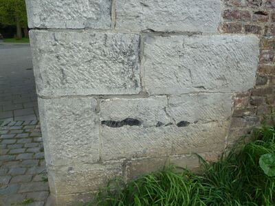 Een hoek van een muur waarin grote blokken lichtgekleurde stenen zijn gebruikt. De helft van de stenen is iets lichter dan de rest.