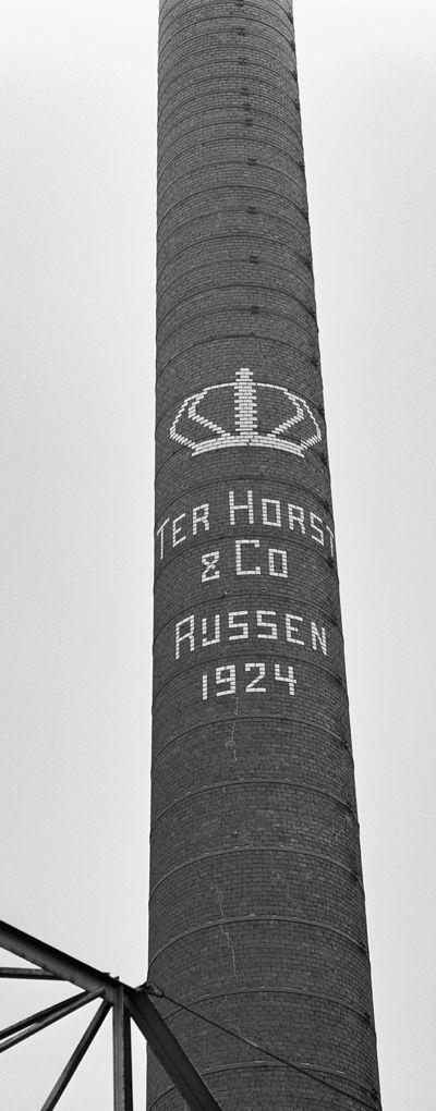Foto van de schoorsteen van de Justespinnerij ter Horst met opschrift Rijssen, 1924