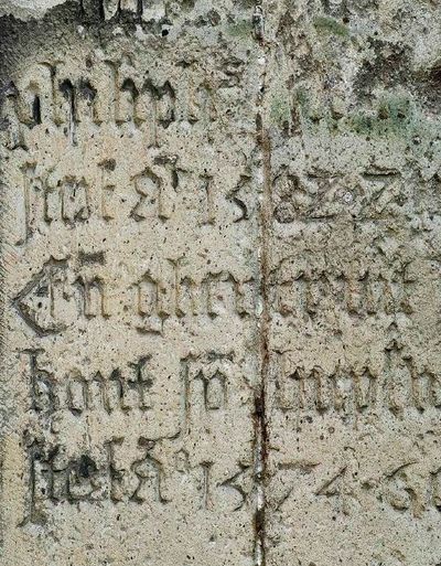 Een stenen grafzerk met erin gegraveerde letters.