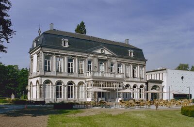 Foto van de zijgevel van Kasteel Vaeshartelt bij Maastricht met een aangebouwde luxe veranda