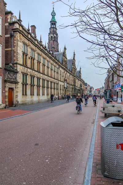 Raadhuis met toren in Leiden. Ervoorlangs loopt een voetpad een fietspad.