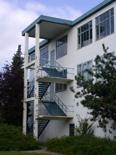 Een trap langs een wit met blauw gebouw.
