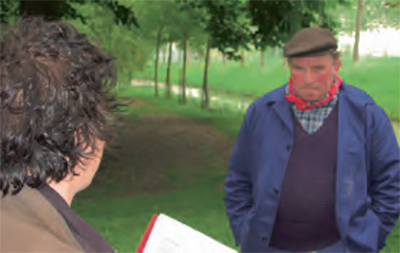 Foto van een boer met rode zakdoek en pet die een verhaal vertelt aan een onderzoeker.