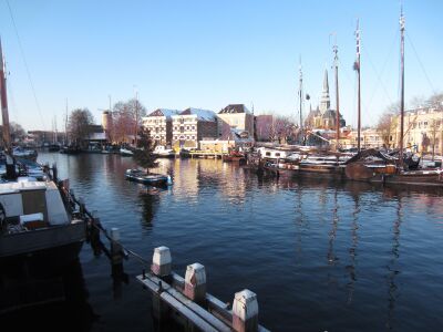 Foto van de oude binnenhaven van Gouda met liggende schepen, op een heldere, zonnige dag.