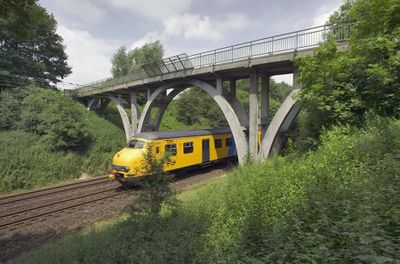 Foto van het viaduct over de spoorlijn bij Klimmen, met daaronder een trein (een hondekop).