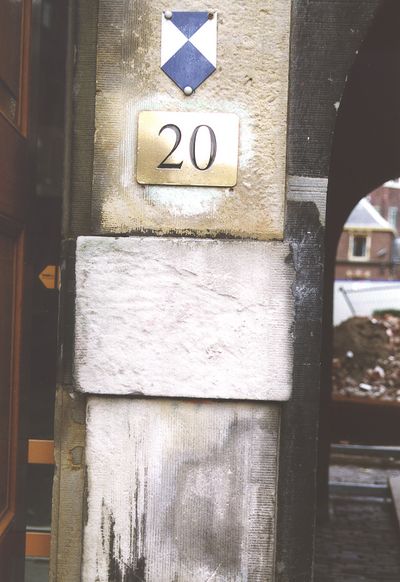 Foto van een zandstenen deuromlijsting die zwaar is beschadigd door het verwijderen van graffiti met verkeerde reinigingstechnieken