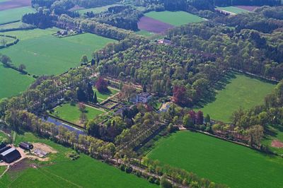 Luchtfoto van Huis Voorstonden. Eromheen zijn de bijbehorende grond en lanen te zien. Het landgoed is omgeven door bomen en grasvelden.