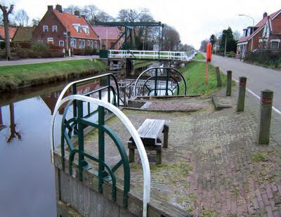 Een aanlegplaats en ophaalbrug in het dorp Keil-Windeweer. Aan beide kanten van de vaart loopt een weg waaraan huizen staan.