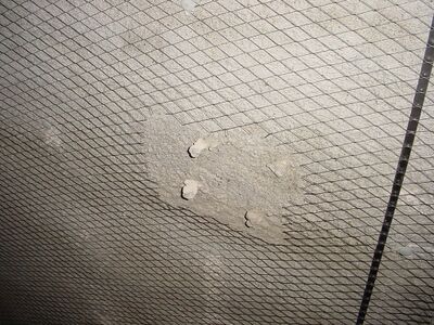 betonnen vloer bedekt met gaas.