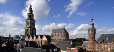 Foto van de Martinitoren in Groningen met daken van andere gebouwen eromheen