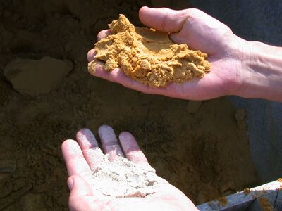 Foto van twee verschillend gekleurde soorten zand die voor het samenstellen van een mortel kunnen worden gebruikt