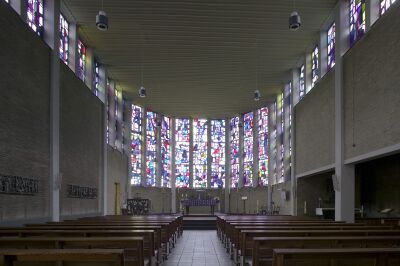 interieur van een moderne kloosterkapel met kleurrijke glas-in-loodramen