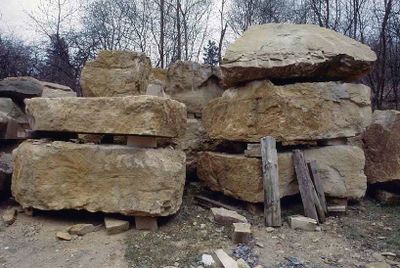 Grote blokken steen liggen opgestapeld in een steengroeve.