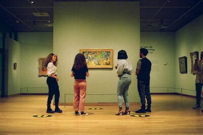 Vier jongeren kijken naar een schilderij in het Van Gogh Museum