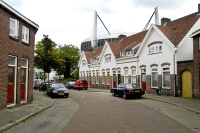 Straat in Philipsdorp, Eindhoven. Achter de huizen is het dak van het voetbalstadion te zien.