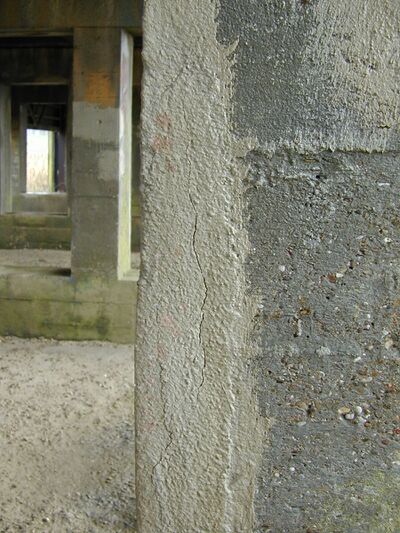 betonnen paal gerestaureerd met kunstharsgebonden materiaal. In de gerestaureerde gedeelte zit een scheur.