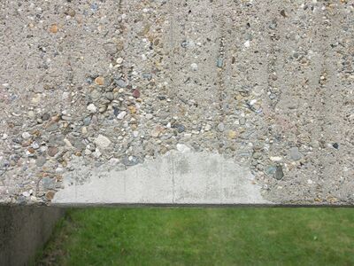 glad grijs betonnen oppervlak met daaromheen ruw beton