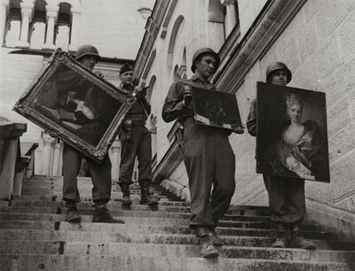 Zwartwit foto van een aantal soldaten die een trap aflopen met schilderijen in hun handen