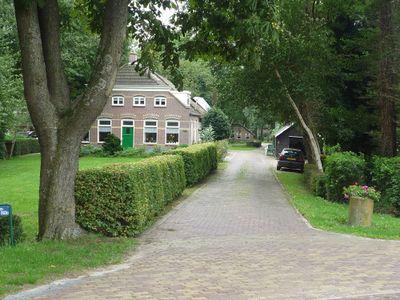 Woning in Staphorst. Oprijlaan met aan het einde een geparkeerde auto. Links een huis met een grasveld ervoor.