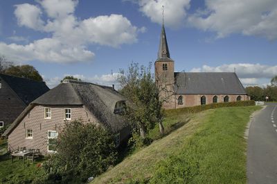 Foto van een kerk tegen een dijk.